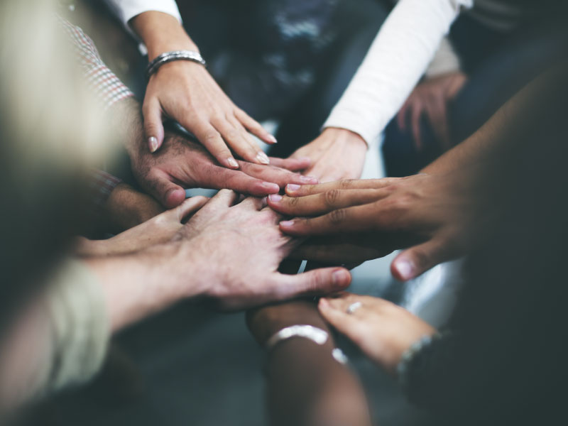 A group of people joining hands together in solidarity