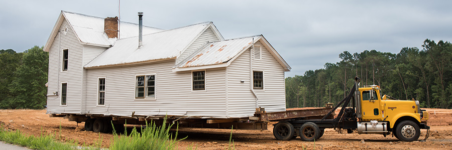 A truck moving  house on a trailer